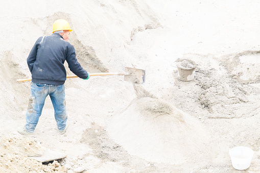 Workers working on cement at construction site