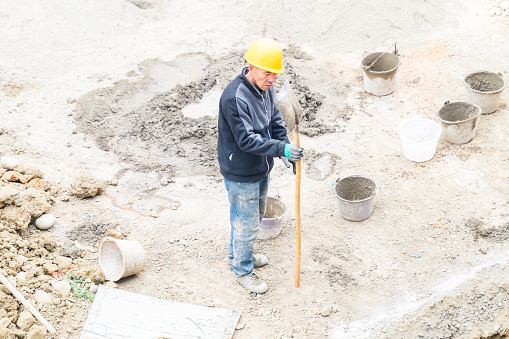 Worker repairing shovel on construction site