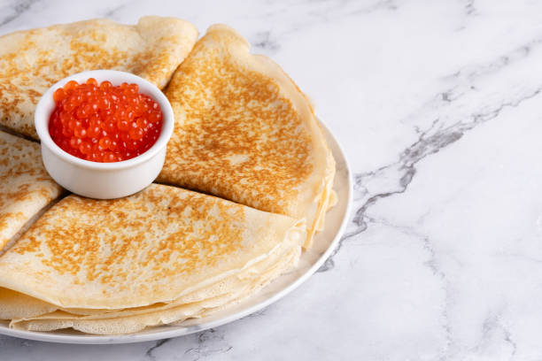 istock Pancakes with red caviar on a marble table, with copy space for text 2074931706