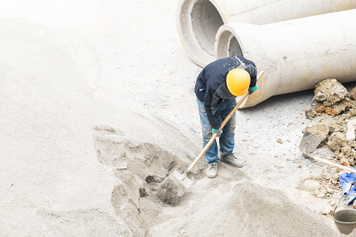 Workers working on cement at construction site