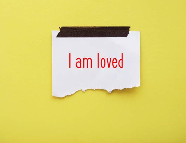 nota adesiva su sfondo giallo con messaggio scritto a mano - sono amato - affermazione positiva auto-amata per aumentare l'autostima - per accettare di essere degni di amore e rispetto - worthy of trust foto e immagini stock
