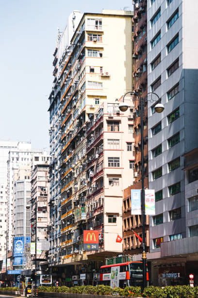 A striking daytime capture of a city's high-density residential architecture, showcasing the juxtaposition of modernity and traditional living spaces against the backdrop of a clear blue sky.
