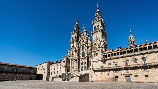 Santiago de Compostela Archcathedral Basilica (Catedral Basilica de Santiago de Compostela) under deep blue summer sky. The archcathedral basilica is a famous place of the pilgrimage on the Way of St James since the Early Middle Ages and marks the traditional end of the pilgrimage route. Empty Plaza Panorama the romanesque structure, with gothic and baroque additions. Santiago de Compostela, A Coruña Province, Galicia, Spain, Europe
