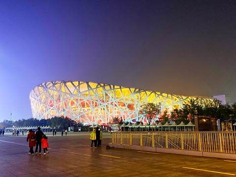 Beijing, China - November 4, 2019 : People Walking Outside Beijing National Stadium At Night. This Stadium Also Known As The “Bird's Nest,” Was The Main Stadium Of The 2008 Beijing Olympic Games.