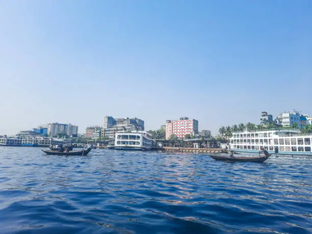 Sadarghat river view landscape, Transporting local people by small boats across the river, Commuter ferryboat in the monsoon, Boat ride in the Buriganga river.