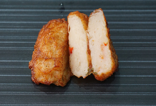 deep fried pork fish meat roll wrapped with bean curd skin ngohiang in plate on dark grey wood table asian dim sum halal food restaurant cuisine banquet menu for cafe