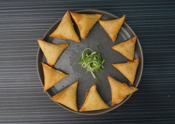 istock deep fried crispy yam taro spring roll samosa Indian triangle in plate on dark grey wood table asian dim sum halal food restaurant cuisine banquet menu for cafe 2075063577