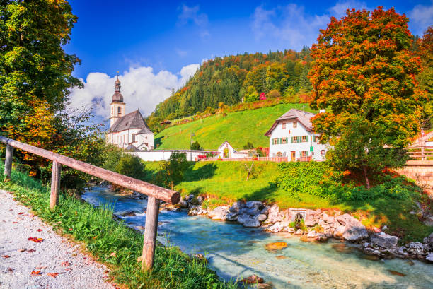 Ramsau, Berchtesgaden - Germany. Autumnal scenery in Berchtesgadener, Bavaria. Parish Church of St. Sebastian and River Ramsauer Ache.