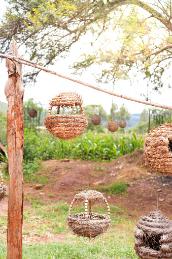 A collection of various baskets hanging from a sturdy wooden pole.