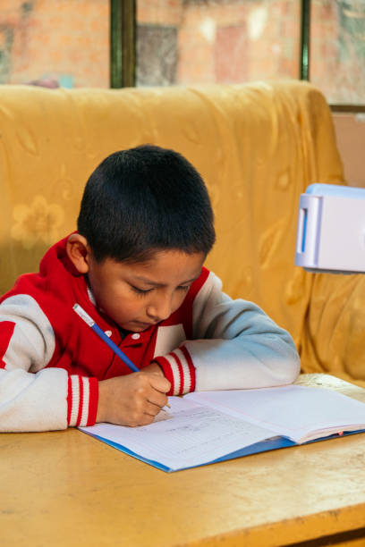 latino child doing his schoolwork with cell phone copying - education concept