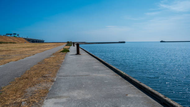 istock Meadow with yellow grass, blue sea and concrete bridge 2075087633