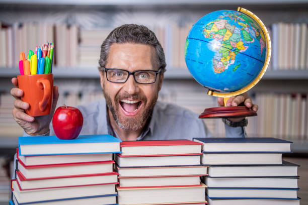 Tutor at classroom. Man geographer with books in classroom. Knowledge and education concept. school teacher with book in classroom. teacher in classroom. Teachers Day. learning and discovery.