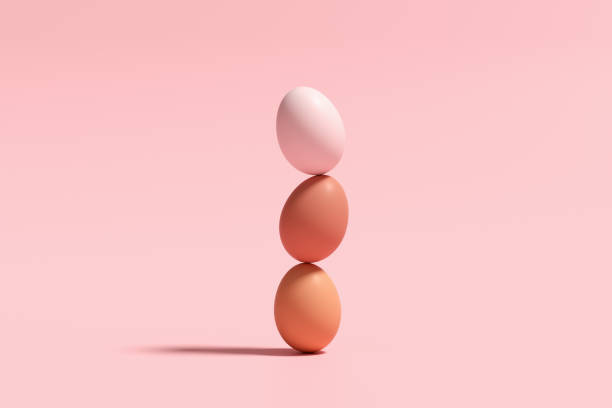 istock Eggs on top of each other balancing against pink background. 2075104308