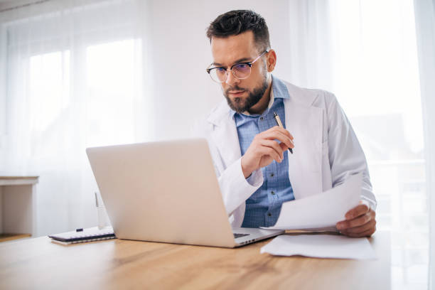 istock Male doctor working in his home office. 2075114539