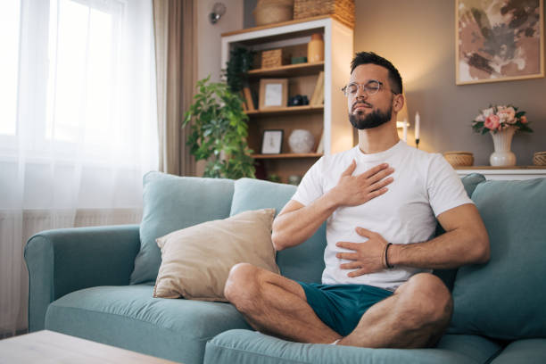 istock A man sits at home and practices yoga. 2075115086