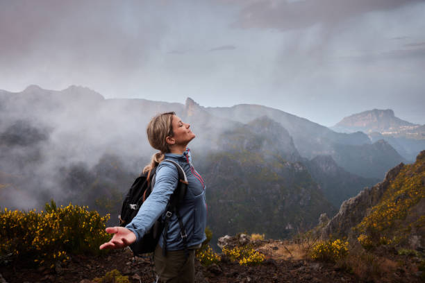 istock Smiling female hiker with her arms outstretched on a mountain. 2075117413