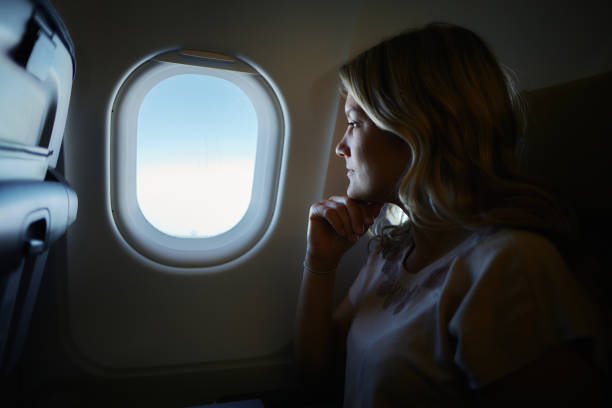 istock Young pensive woman traveling by plane. 2075122305