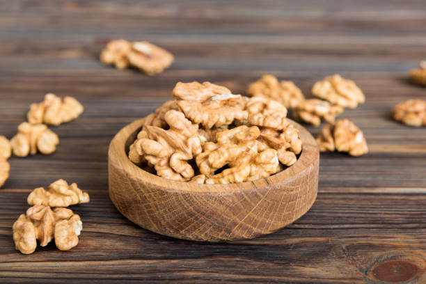 istock Fresh healthy walnuts in bowl on colored table background. Top view Healthy eating bertholletia concept. Super foods 2075136317