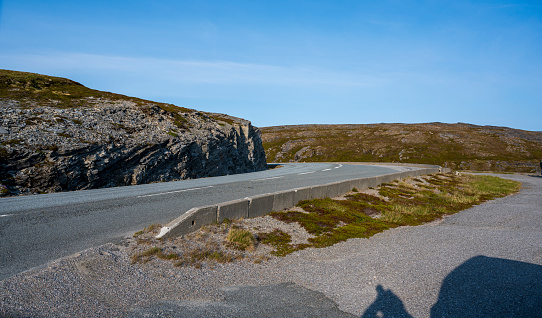 Asphalt road in the tundra near the rocky hills