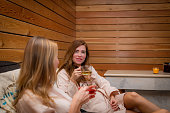 Relaxing in the sauna: two women on sun loungers with tea