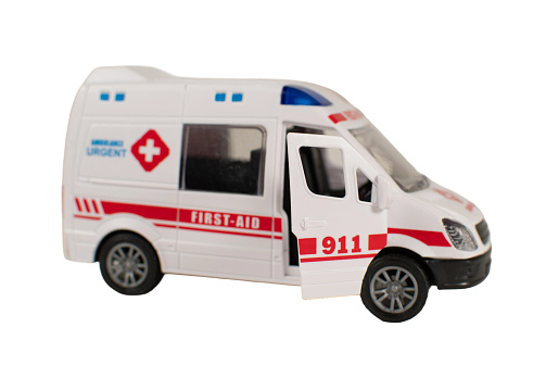 A white ambulance with red cross on the side and the words First Aid on the door