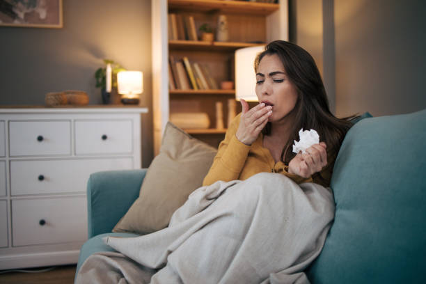 istock Sick woman sitting on sofa at home. 2075188422