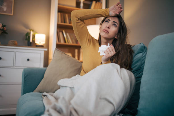 istock Sick woman sitting on sofa at home. 2075188425