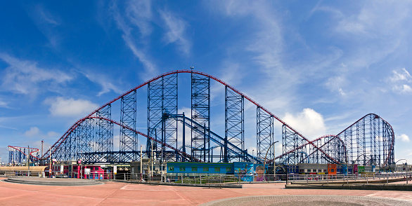 View of the rollercoaster in the centre of Blackpool, UK.  People can be seen walking on the promenade