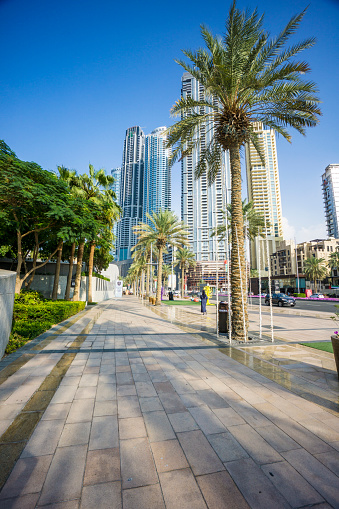 Dubai - UAE - December 8. 2019 - The typical high-rise buildings on Sheikh Zayed Road are a real eye-catcher in Dubai. The paradise road with multi-lane road and elevated railroad is the center of Dubai. Expensive cars can be seen as well as busy foreign employees and curious tourists. In the evening light the glass facades are especially beautiful