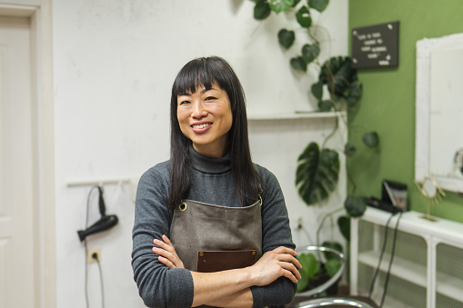 Picture of a Japanese hair stylist in her little salon, showing that her small business is doing well.