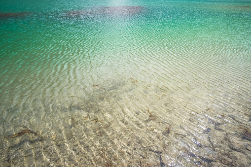 Blue turquoise saturated water of Kulikalon Lake in the Fan Mountains in Tajikistan, cold mountain lake