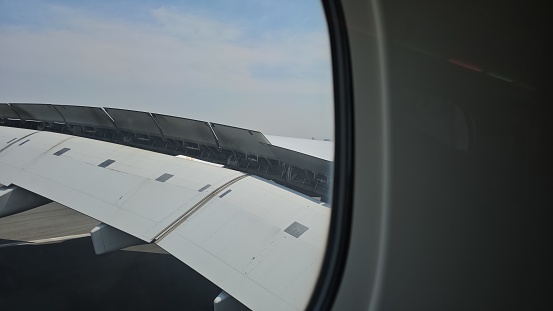 Airplane wing with flaps and spoilers fully extended to slow down the aircraft after landing