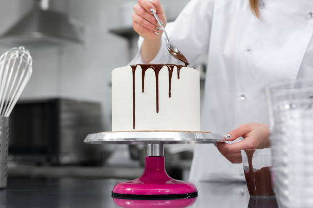 istock Pastry chef decorates the cake with chocolate streaks 2075270177