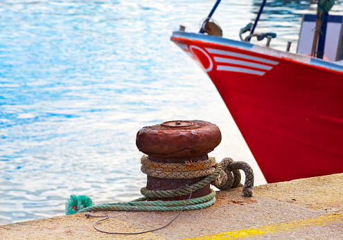 White fenders suspended between a boat and dockside for protection. Maritime fenders