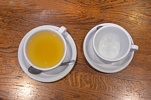 The hot teacup and teapot transparent on the table with copy space.