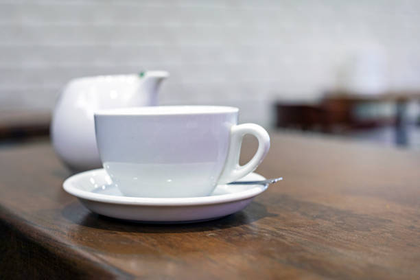 white cup and teapot on the table. Morning snack
