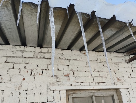 spring icicles on the roof of a house