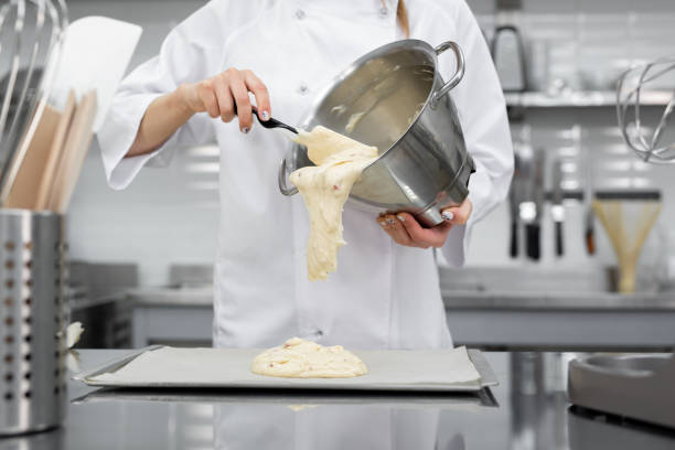 istock Pastry chef pours the biscuit on the baking parchment 2075300084