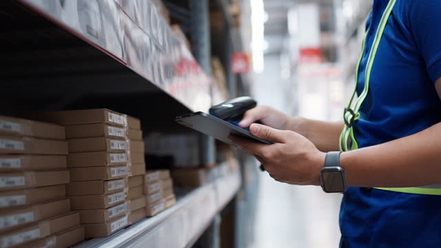 Warehouse workers use digital tablet with scanners to check and scan the barcode of stock inventory to keep storage in a system.