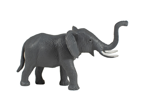 A large toy elephant standing near the corner of an otherwise empty, blank white walled room. Conceptually portraying the often unspoken \
