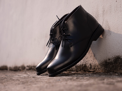 Men fashion black boots leather on the ground.