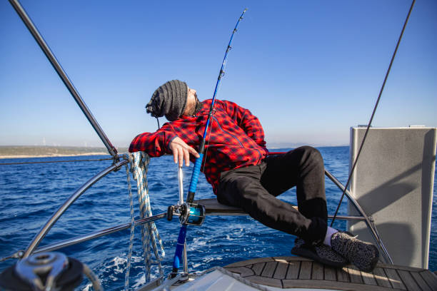 istock Man sitting and fishing on boat 2075334138