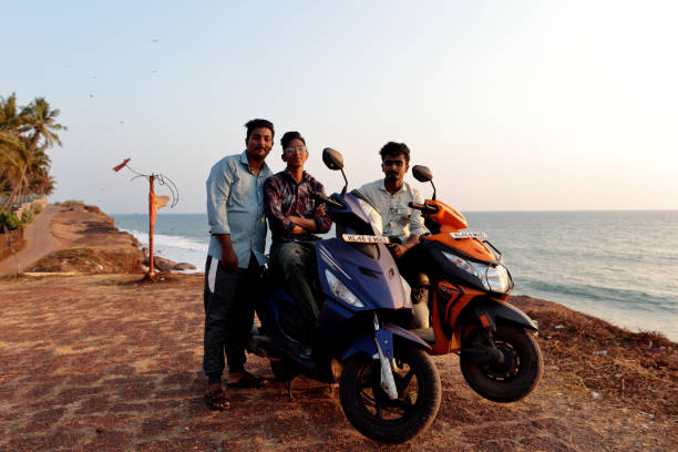 Varkala, Kerala, India - February 22, 2024: Indian local guys on scooters posing on the cliff