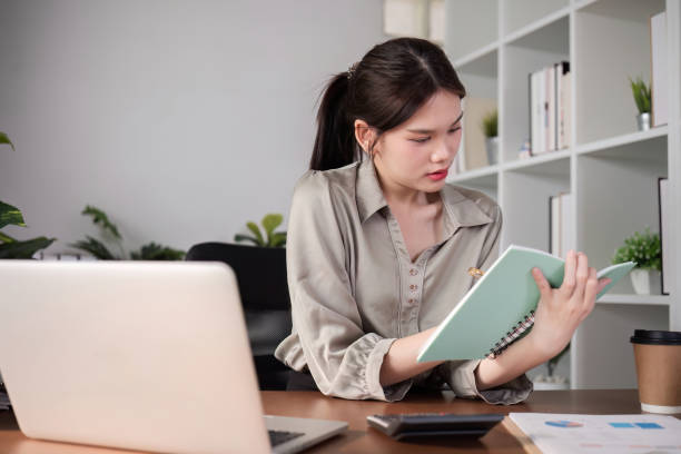 istock Young Asian student studies online about graphs and statistics. Happy Zoom video call studying with laptop computer 2075352677