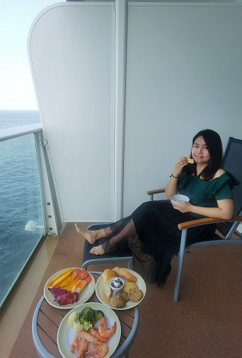 An Asian woman is enjoying cruise holiday