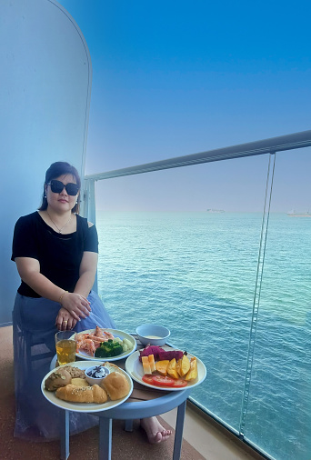 An Asian woman is enjoying cruise holiday