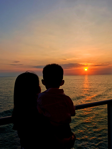 An Asian woman and her young son are enjoying cruise holiday