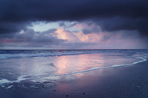 Majestic sunrise sunset sky background with soft colorful clouds and dramatic storm sky over the North Sea on the Dutch coast. Texel, Netherlands