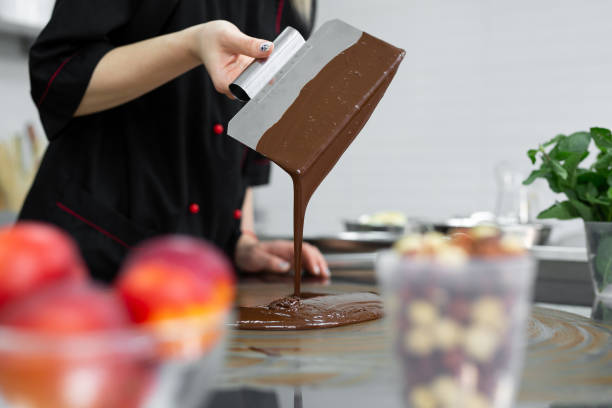 istock Close-up of a pastry chef using spatulas tempering molten chocolate. 2075362189