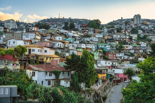 typical colorful houses in the hills of Valparaiso under blue sky at late afternoon